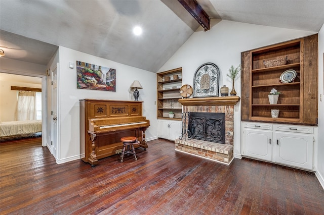 sitting room featuring lofted ceiling with beams, built in shelves, a fireplace, and dark hardwood / wood-style floors