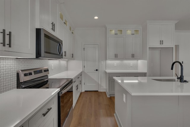 kitchen with white cabinetry, light hardwood / wood-style floors, appliances with stainless steel finishes, and sink