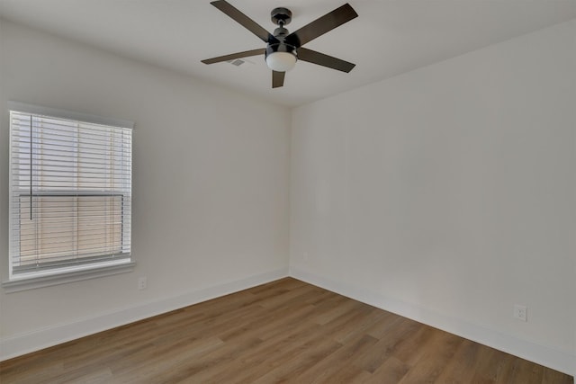 empty room with plenty of natural light, ceiling fan, and hardwood / wood-style flooring