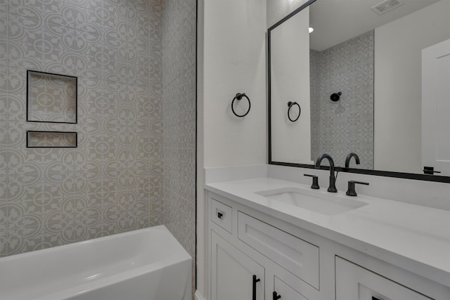 bathroom featuring vanity and tiled shower / bath