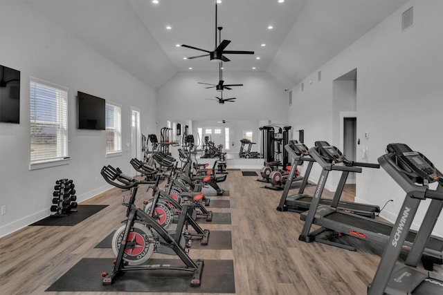 gym featuring high vaulted ceiling, ceiling fan, and light wood-type flooring