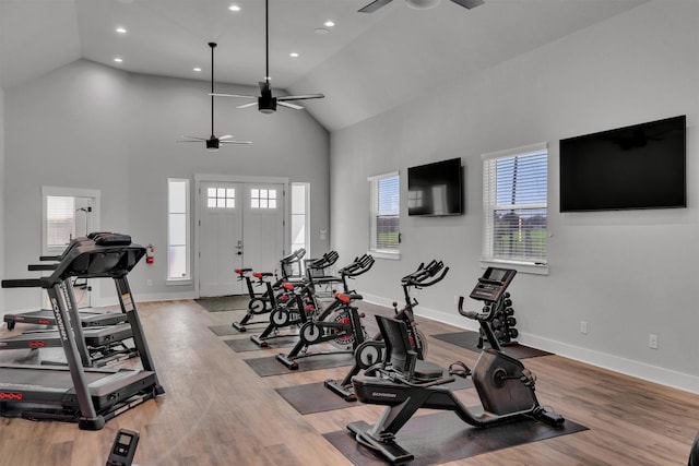 exercise room featuring high vaulted ceiling, ceiling fan, and light wood-type flooring