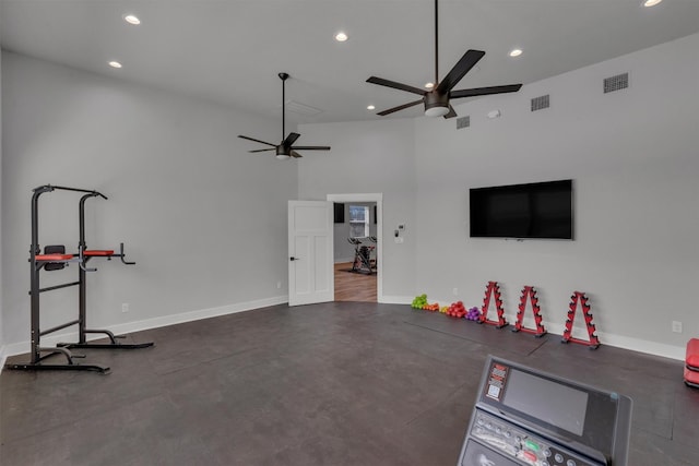 workout area featuring ceiling fan and a towering ceiling