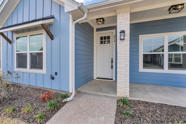 view of exterior entry featuring covered porch