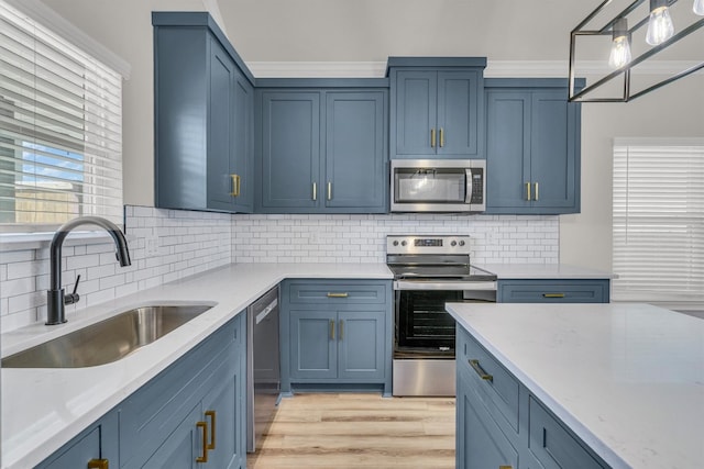 kitchen featuring light stone countertops, appliances with stainless steel finishes, sink, light hardwood / wood-style flooring, and tasteful backsplash