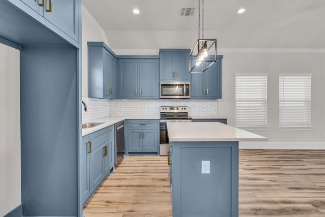 kitchen with pendant lighting, light hardwood / wood-style floors, appliances with stainless steel finishes, and a center island