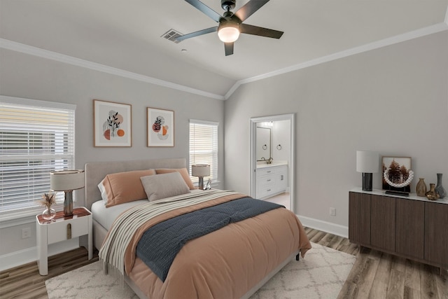 bedroom featuring lofted ceiling, ceiling fan, connected bathroom, light wood-type flooring, and crown molding