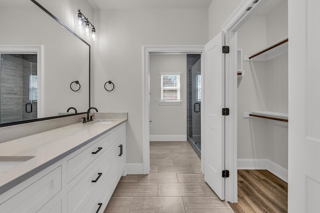 bathroom with tile flooring, double sink, large vanity, and an enclosed shower