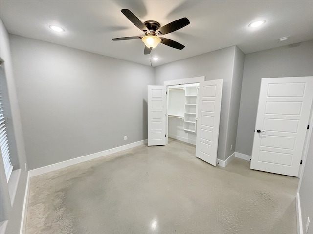 unfurnished bedroom with a spacious closet, a closet, and ceiling fan