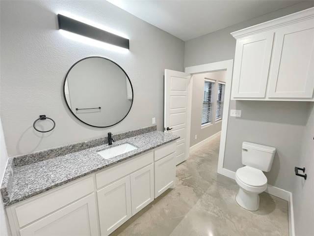 bathroom featuring toilet, vanity, and tile flooring