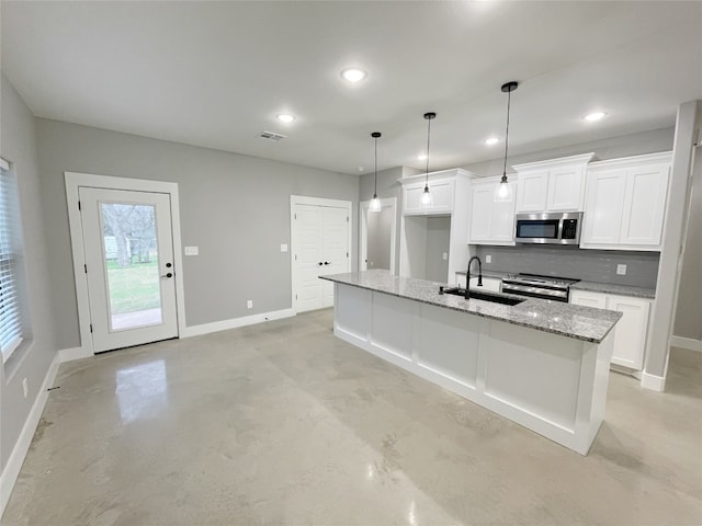 kitchen with a kitchen island with sink, stainless steel appliances, tasteful backsplash, and white cabinetry