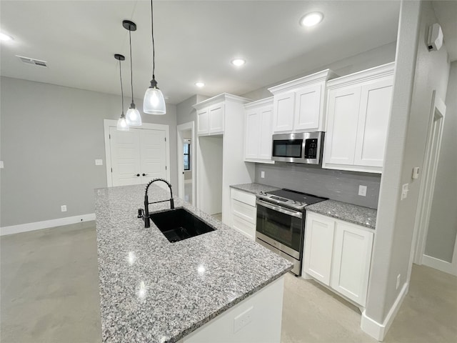 kitchen with white cabinetry, an island with sink, stainless steel appliances, light stone countertops, and sink