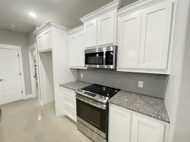 kitchen with white cabinets, appliances with stainless steel finishes, dark stone counters, and backsplash