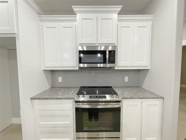 kitchen featuring white cabinets, tasteful backsplash, and stainless steel appliances