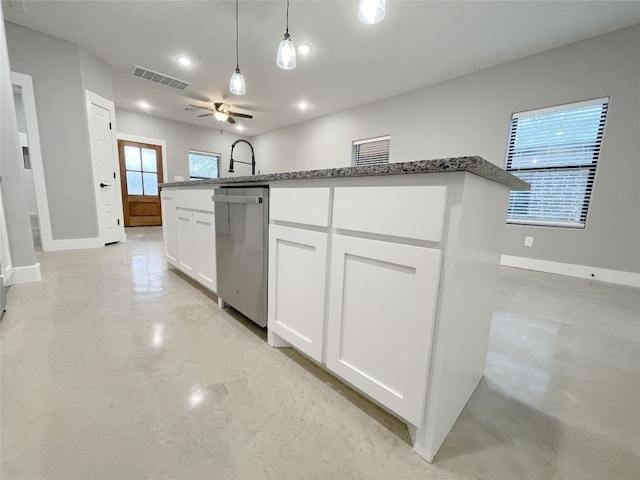 kitchen featuring stainless steel dishwasher, hanging light fixtures, ceiling fan, dark stone countertops, and white cabinets