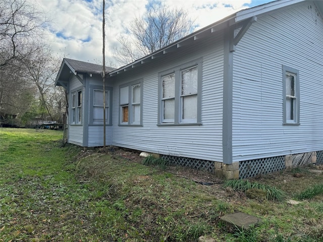 view of side of home with a yard