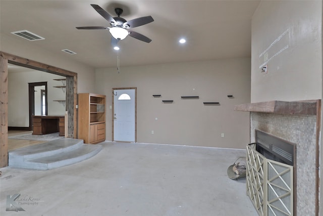 unfurnished living room featuring concrete floors, a tile fireplace, and ceiling fan