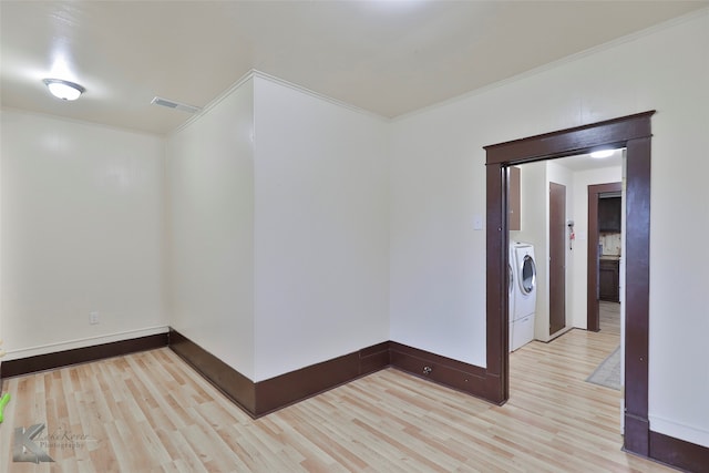 unfurnished room featuring ornamental molding, washer / dryer, and light wood-type flooring