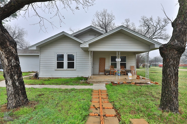 view of front of property with covered porch and a front lawn