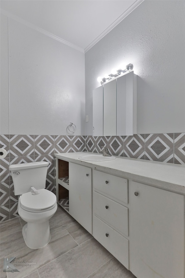 bathroom with vanity, toilet, tile patterned floors, and tile walls