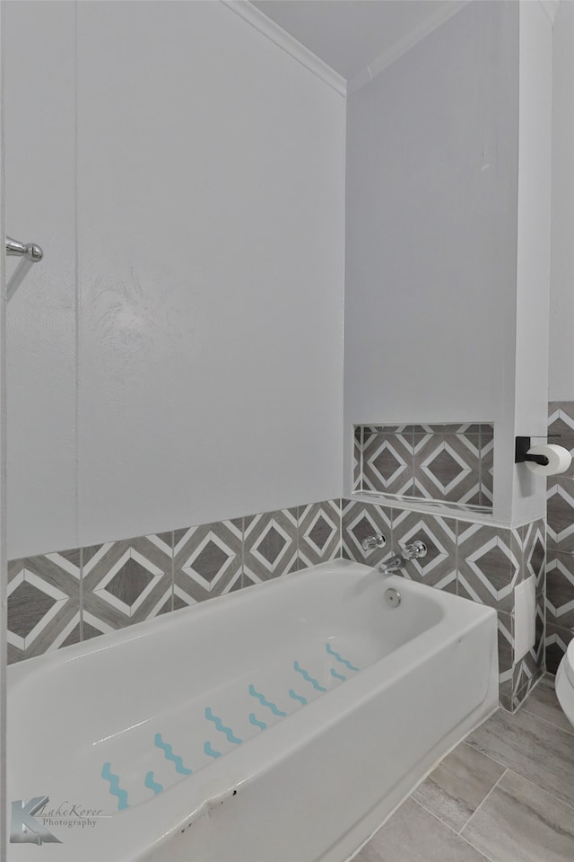 bathroom featuring a washtub and crown molding