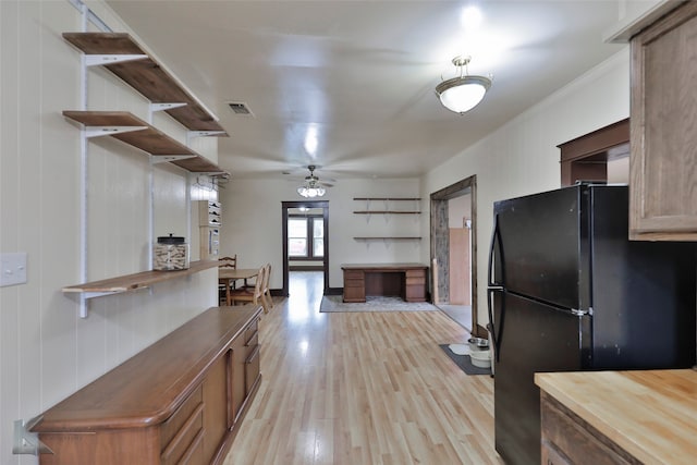 kitchen with light hardwood / wood-style flooring, ceiling fan, and black fridge