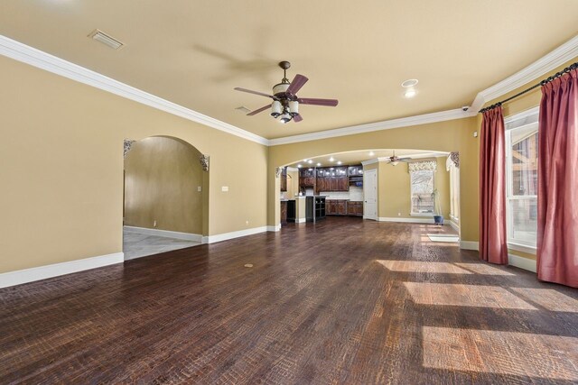 unfurnished living room featuring ceiling fan, ornamental molding, and dark wood-type flooring