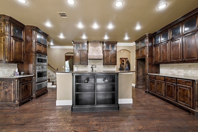 kitchen with dark brown cabinetry and premium range hood