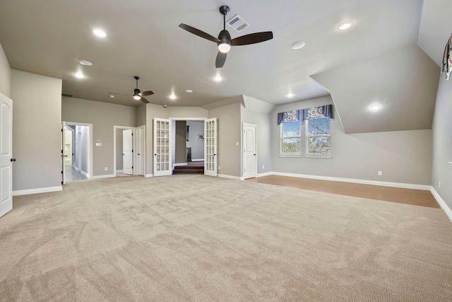 interior space with lofted ceiling, ceiling fan, and light colored carpet