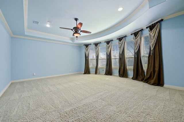 carpeted spare room featuring ceiling fan, a raised ceiling, and crown molding