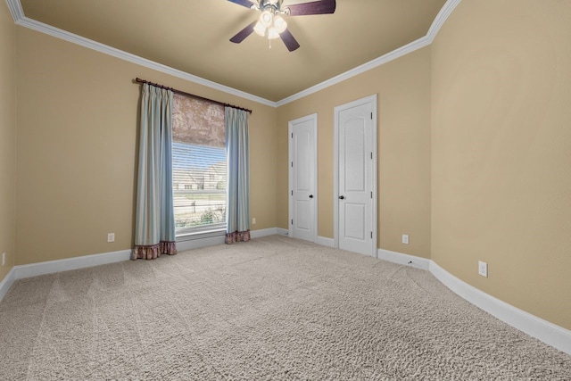 empty room featuring ceiling fan, crown molding, and carpet