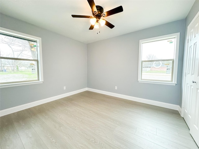empty room with light wood-style floors, baseboards, and a healthy amount of sunlight