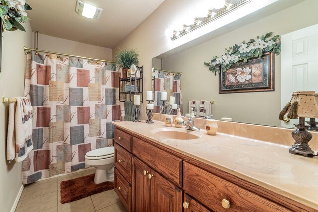 bathroom with tile flooring, toilet, and vanity