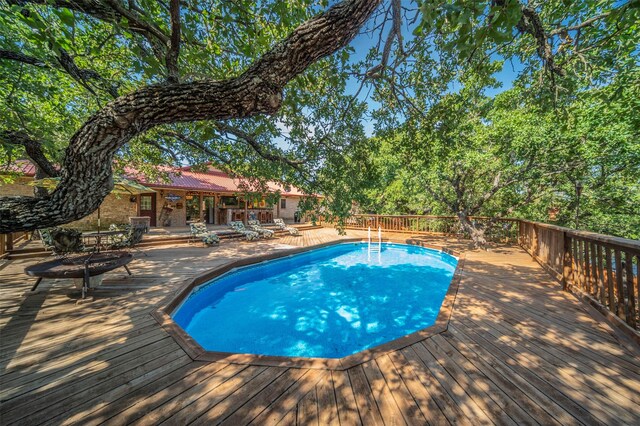 view of pool featuring a patio and a wooden deck