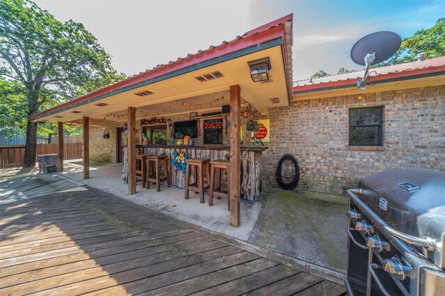 deck featuring a grill and exterior bar