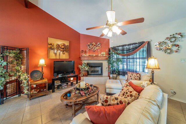 living room with high vaulted ceiling, tile flooring, a tiled fireplace, and ceiling fan