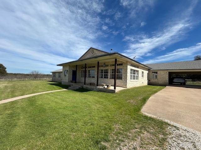 back of house with a lawn and a carport