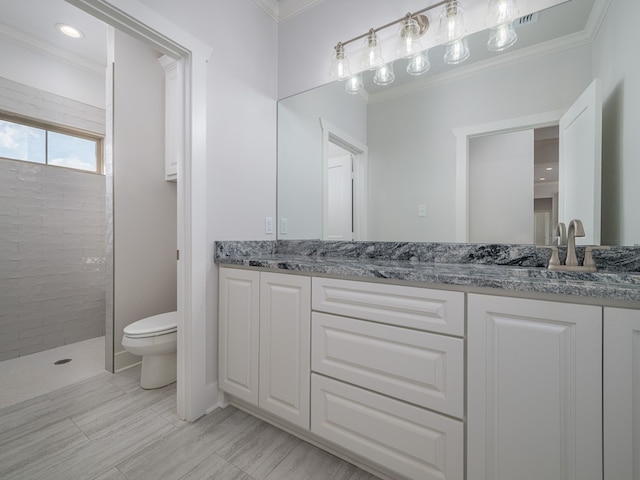 bathroom featuring toilet, tile flooring, tiled shower, dual vanity, and ornamental molding