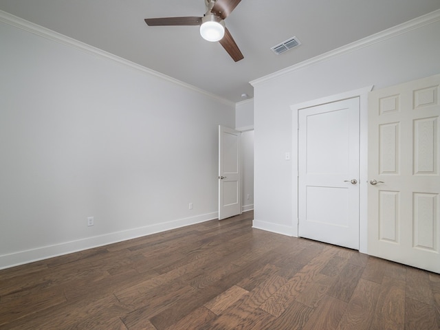 unfurnished bedroom with dark hardwood / wood-style floors, ceiling fan, and crown molding