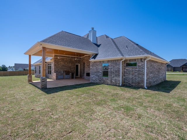 rear view of house featuring a lawn and a patio area