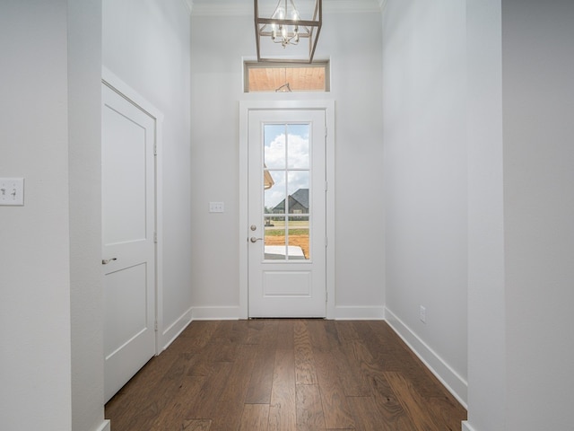 entryway with a chandelier, ornamental molding, and dark hardwood / wood-style flooring