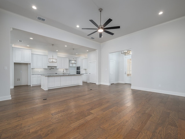 unfurnished living room featuring ceiling fan with notable chandelier, sink, dark wood-type flooring, and ornamental molding