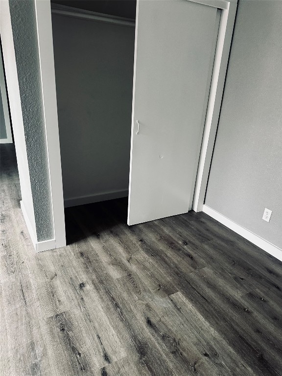 unfurnished bedroom featuring dark hardwood / wood-style floors and a closet