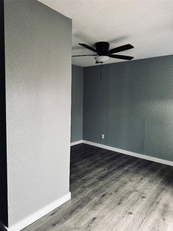 unfurnished room featuring ceiling fan and dark hardwood / wood-style flooring