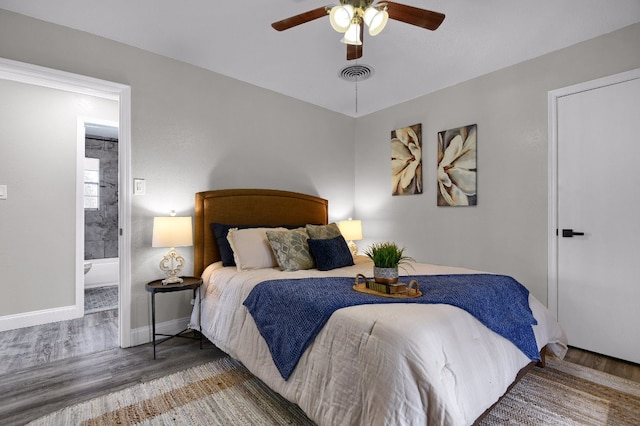 bedroom featuring ceiling fan, ensuite bathroom, and dark wood-type flooring