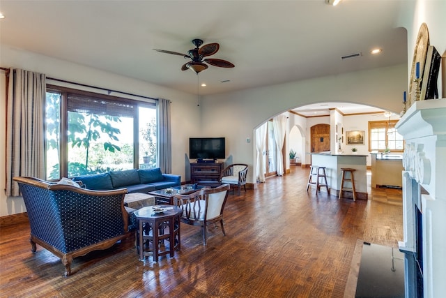 living room with ceiling fan and dark wood-type flooring