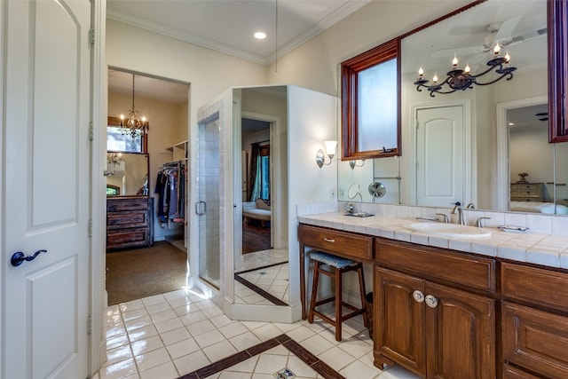 bathroom featuring tile patterned floors, ornamental molding, ceiling fan with notable chandelier, vanity, and a shower with shower door