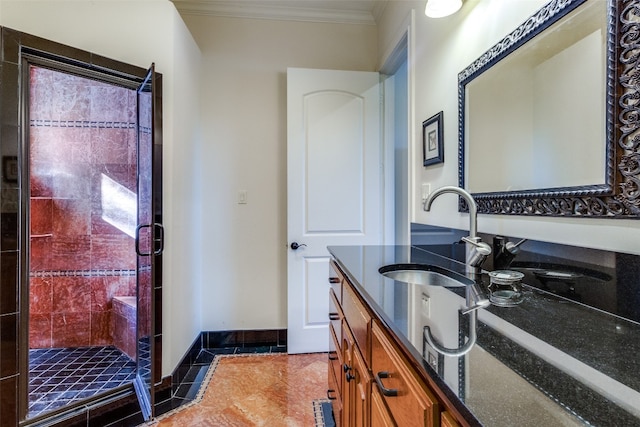 bathroom with tile patterned floors, crown molding, vanity, and tiled shower