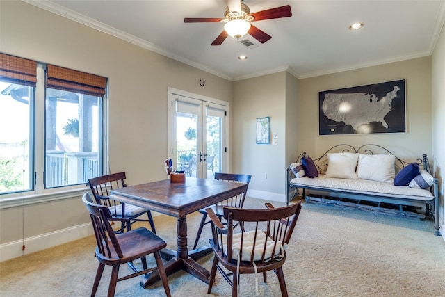 carpeted dining space with ceiling fan, ornamental molding, and french doors