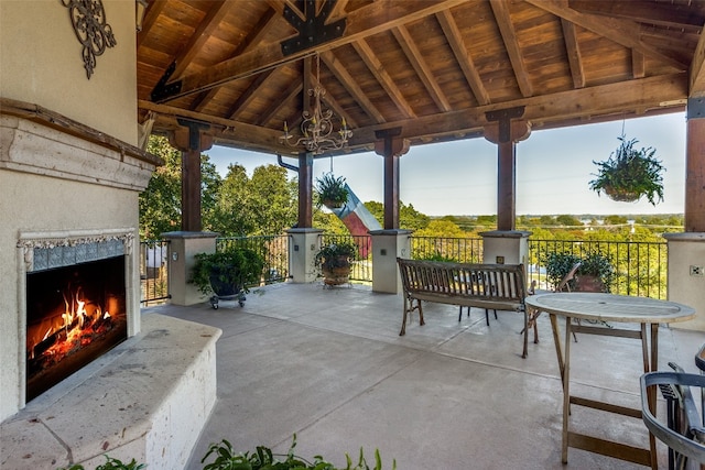 view of patio / terrace featuring a gazebo and an outdoor stone fireplace